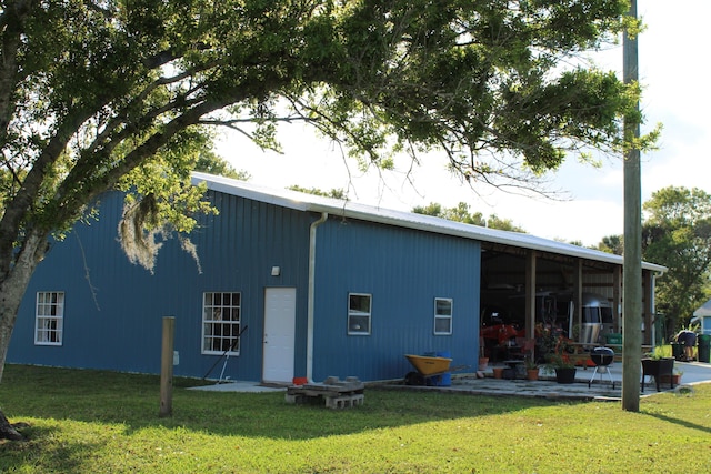 rear view of property with a pole building and a lawn