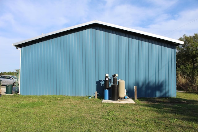 view of property exterior featuring a lawn and an outbuilding