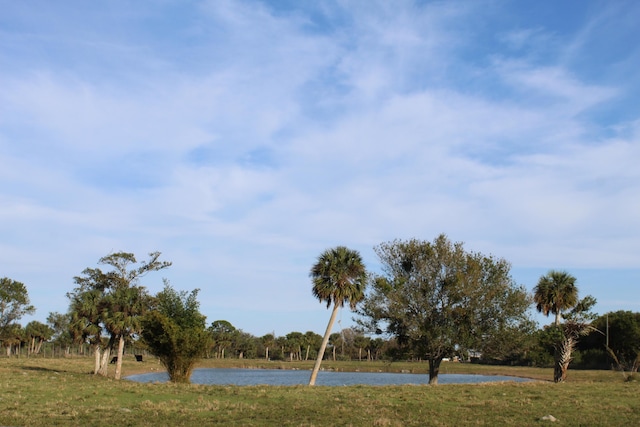 view of home's community featuring a lawn and a water view