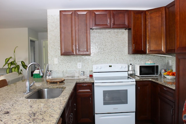 kitchen with black microwave, white range with electric cooktop, a sink, and backsplash