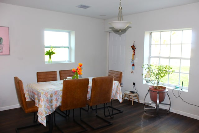 dining room featuring plenty of natural light, visible vents, baseboards, and dark wood finished floors