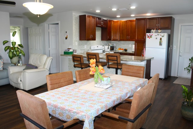 dining area with dark wood-style floors and recessed lighting