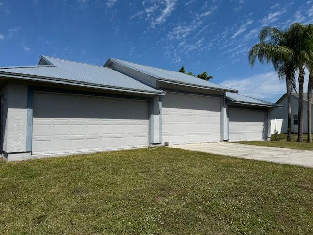 exterior space featuring a garage, driveway, a lawn, and stucco siding