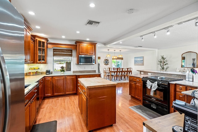 kitchen featuring appliances with stainless steel finishes, a healthy amount of sunlight, visible vents, and light wood-style flooring