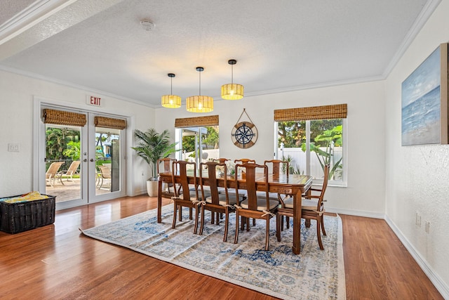 dining area featuring baseboards, french doors, wood finished floors, crown molding, and a textured ceiling