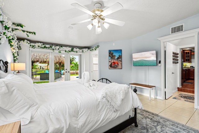 bedroom featuring light tile patterned floors, visible vents, access to outside, a textured ceiling, and french doors