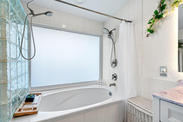 full bath with tiled shower / bath combo, vanity, and tile walls