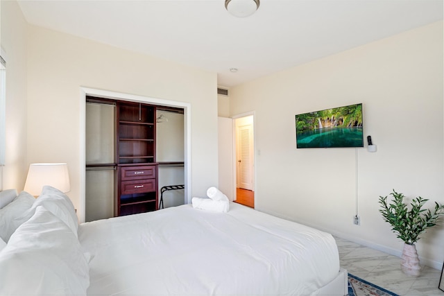 bedroom with marble finish floor, a closet, visible vents, and baseboards