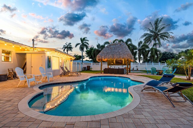 view of swimming pool featuring a fenced in pool, a fenced backyard, a gazebo, a patio area, and an outdoor living space