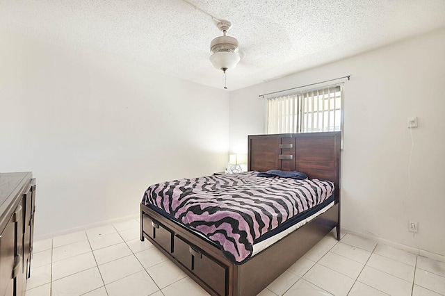 bedroom featuring light tile patterned floors, a ceiling fan, baseboards, and a textured ceiling