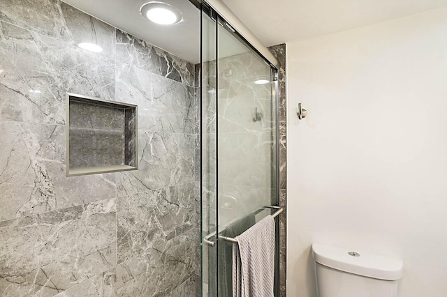 full bath featuring a shower stall and toilet