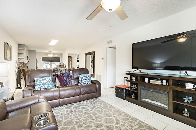 living area with tile patterned floors, visible vents, and a ceiling fan