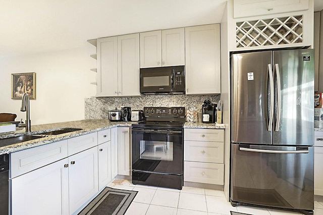 kitchen with a sink, backsplash, light stone countertops, black appliances, and open shelves