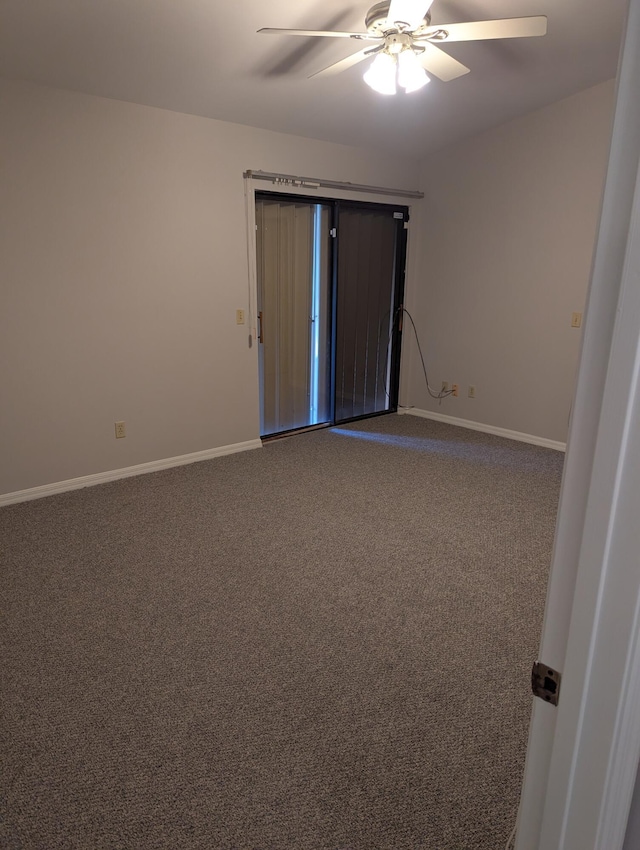 carpeted empty room featuring ceiling fan and baseboards