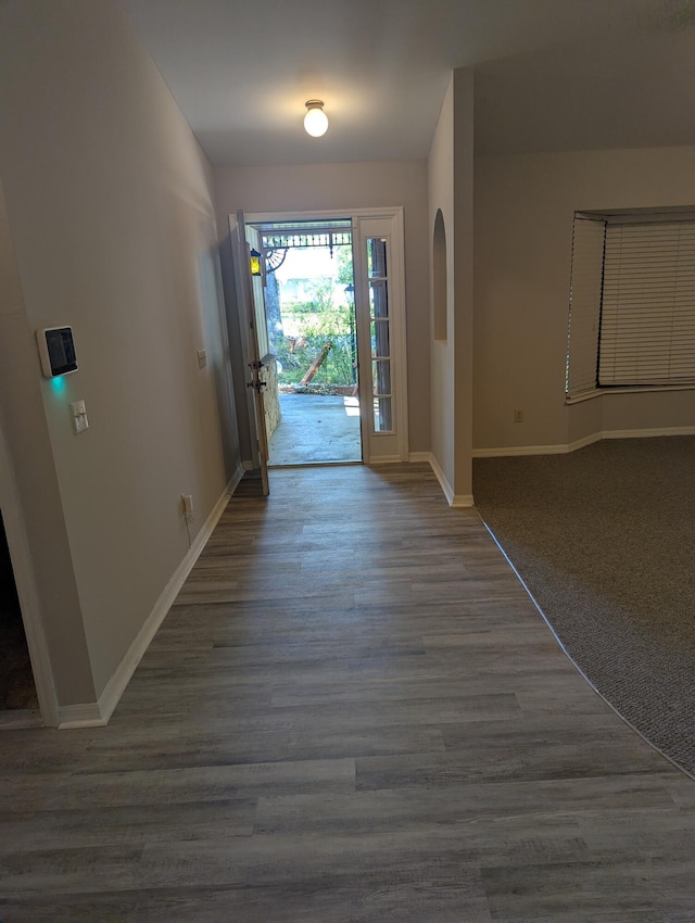 foyer with baseboards and wood finished floors