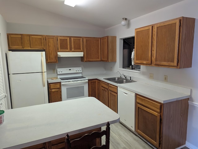 kitchen featuring a sink, light wood finished floors, white appliances, brown cabinetry, and under cabinet range hood
