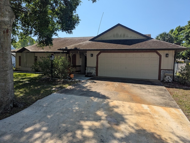 single story home featuring an attached garage, roof with shingles, driveway, and stone siding