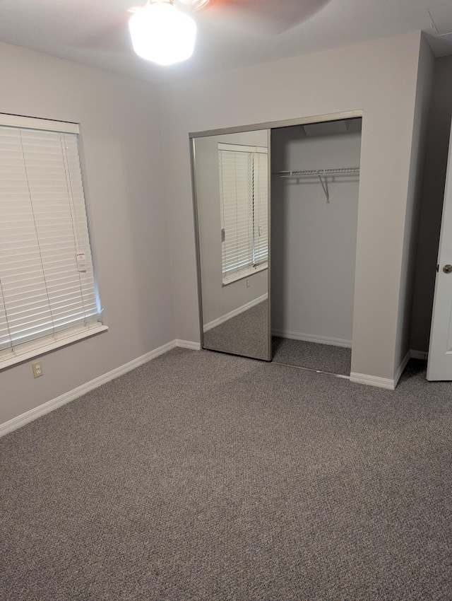 unfurnished bedroom featuring carpet floors, baseboards, and a closet