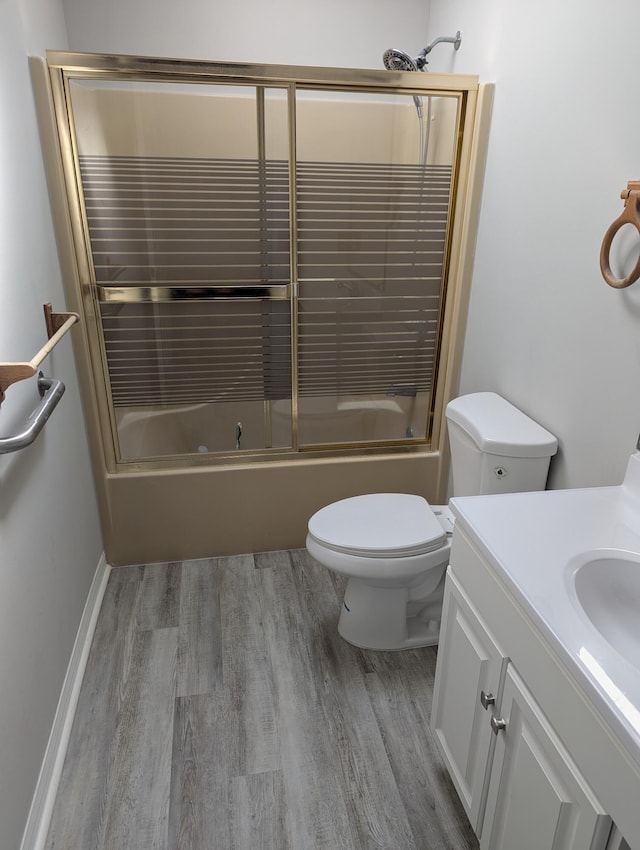 full bathroom with toilet, enclosed tub / shower combo, wood finished floors, and vanity