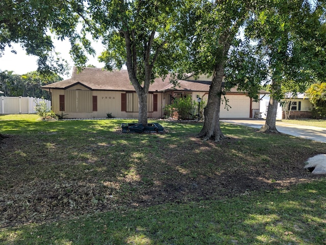 single story home featuring concrete driveway, an attached garage, fence, and a front yard