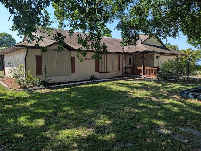 view of front facade with roof with shingles and a front yard