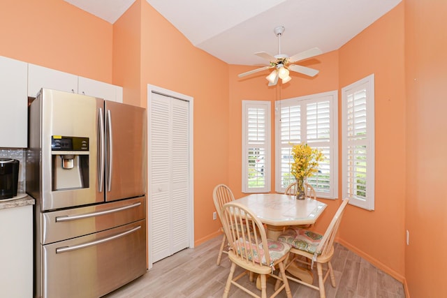 dining room featuring a ceiling fan, baseboards, and light wood finished floors