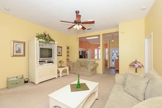 living area featuring ceiling fan, visible vents, and light carpet