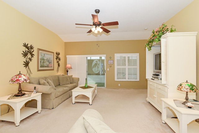 living room featuring a ceiling fan, vaulted ceiling, and light colored carpet