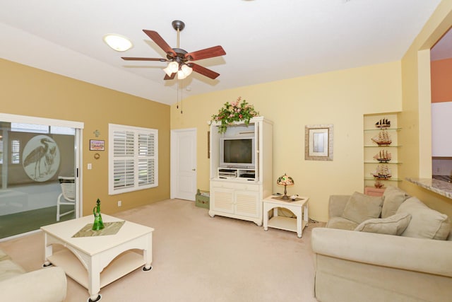 living area featuring light carpet, ceiling fan, and vaulted ceiling