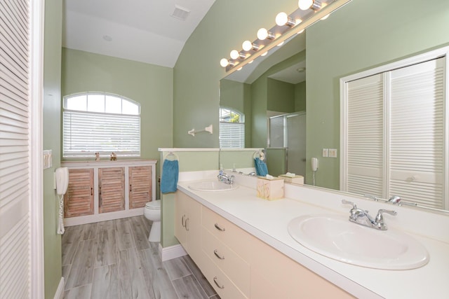 bathroom with double vanity, visible vents, a shower stall, and a sink