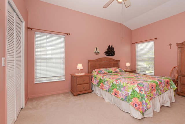 carpeted bedroom with a closet, ceiling fan, and vaulted ceiling