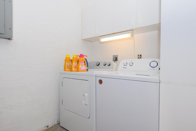 clothes washing area with a textured wall, cabinet space, electric panel, and washer and clothes dryer