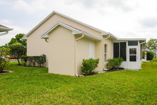 view of property exterior with stucco siding and a yard