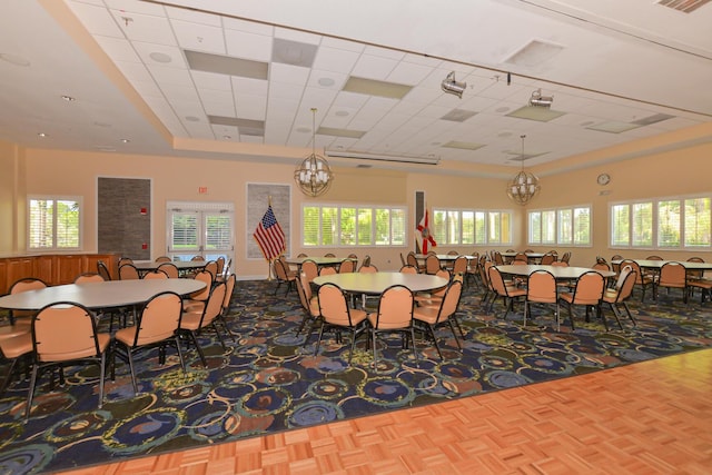 dining room with a notable chandelier, visible vents, and a drop ceiling