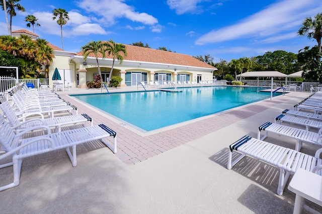 community pool featuring a patio and fence