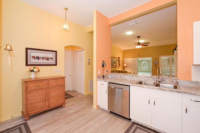 kitchen with visible vents, white cabinetry, arched walkways, a sink, and stainless steel dishwasher