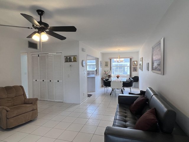 living room featuring light tile patterned floors, ceiling fan with notable chandelier, and visible vents