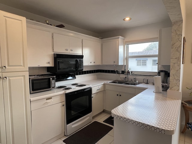 kitchen featuring black microwave, a sink, decorative backsplash, electric range oven, and stainless steel microwave