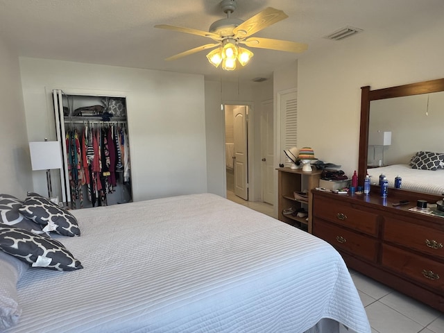 bedroom featuring light tile patterned floors, ceiling fan, visible vents, and a closet