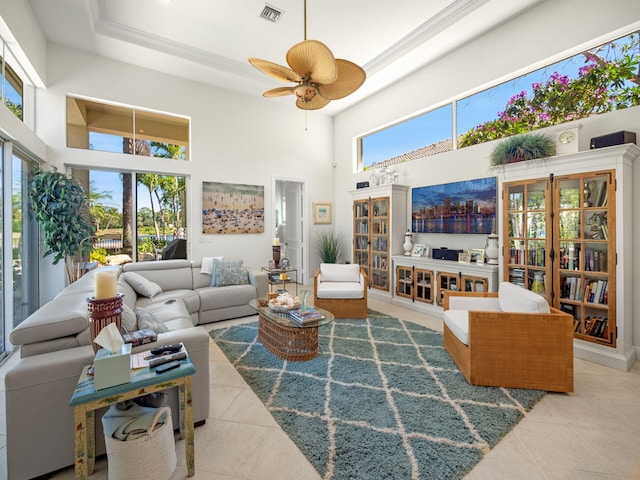 living room featuring a tray ceiling, visible vents, a towering ceiling, and tile patterned flooring