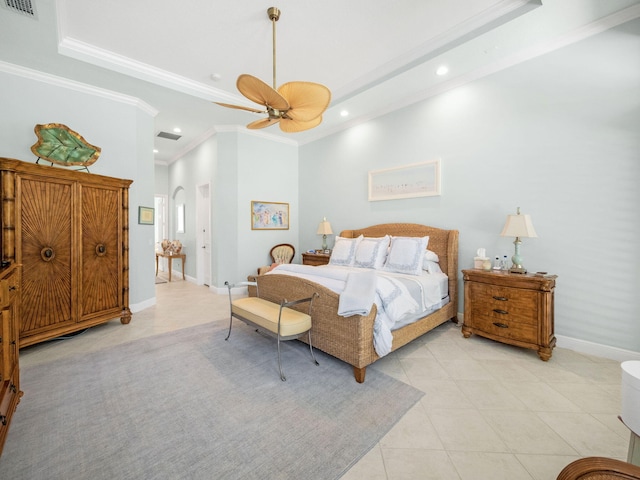 bedroom featuring a tray ceiling, arched walkways, light tile patterned flooring, crown molding, and baseboards