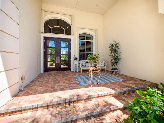 view of exterior entry with french doors and stucco siding