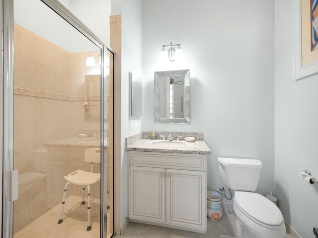 bathroom featuring toilet, a stall shower, and vanity