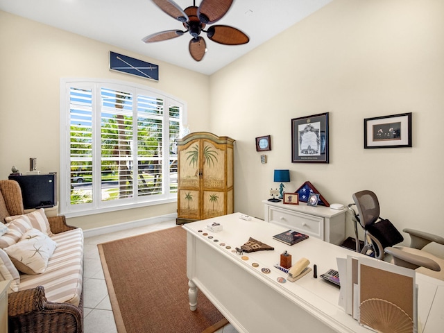 office area with tile patterned flooring, a ceiling fan, and baseboards