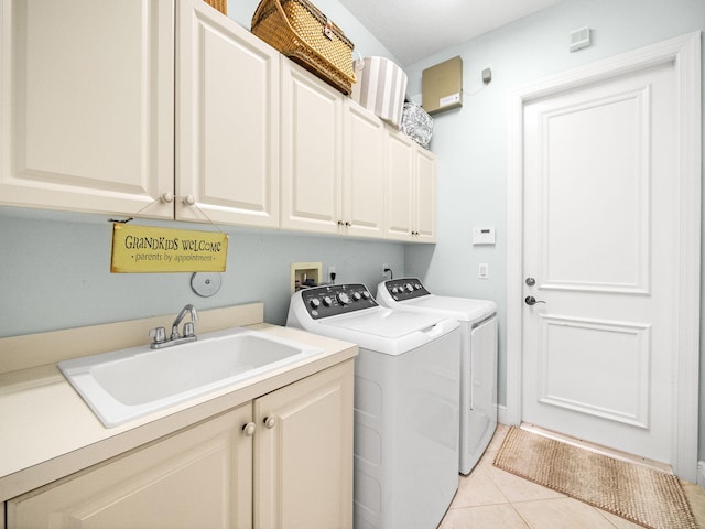 laundry room with light tile patterned floors, cabinet space, independent washer and dryer, and a sink