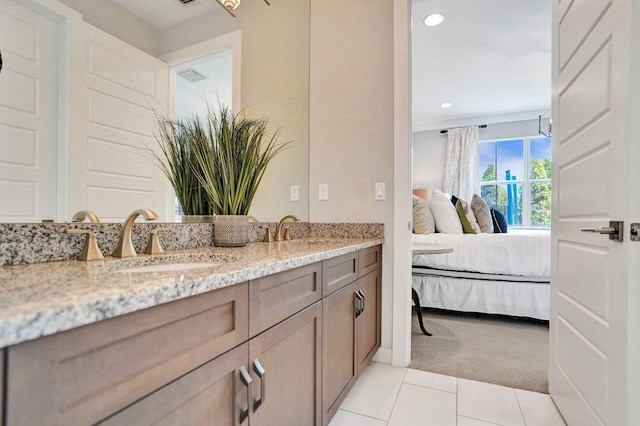 ensuite bathroom featuring a sink, ensuite bath, recessed lighting, tile patterned flooring, and double vanity