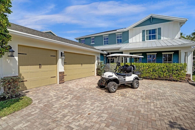 view of front of property featuring decorative driveway, board and batten siding, and an attached garage