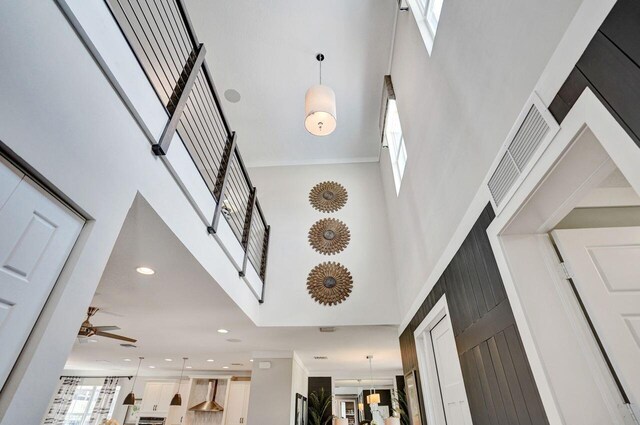 foyer with recessed lighting, visible vents, ceiling fan, and a towering ceiling