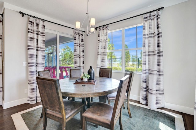 dining space featuring an inviting chandelier, wood finished floors, and baseboards