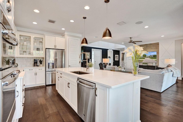 kitchen with visible vents, dark wood-type flooring, a sink, stainless steel appliances, and light countertops